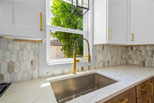 1314 Chalkstone Ave, Providence, RI 02908 - kitchen featuring a sink, decorative backsplash, white cabinetry, and light stone counters