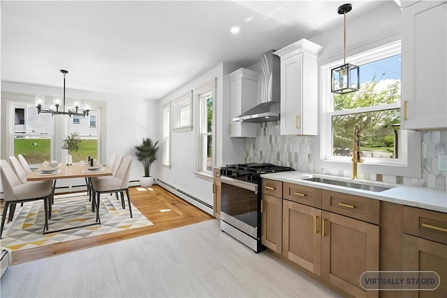 1314 Chalkstone Ave, Providence, RI 02908 - kitchen featuring gas range, wall chimney exhaust hood, a chandelier, a baseboard heating unit, and a sink
