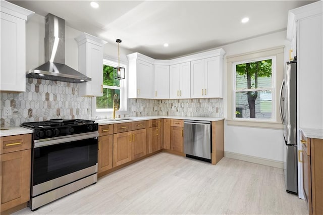 1314 Chalkstone Ave, Providence, RI 02908 - kitchen with stainless steel appliances, wall chimney exhaust hood, a sink, light wood-style flooring, and light countertops