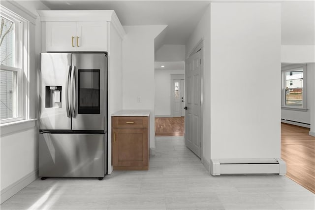 1314 Chalkstone Ave, Providence, RI 02908 - kitchen featuring stainless steel refrigerator with ice dispenser, a baseboard heating unit, white cabinets, and baseboards