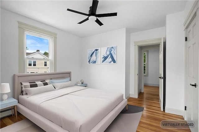 1314 Chalkstone Ave, Providence, RI 02908 - bedroom with light wood finished floors, multiple windows, a baseboard radiator, and ceiling fan