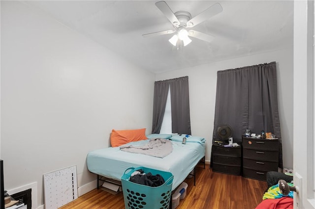 bedroom featuring wood finished floors, a ceiling fan, and baseboards