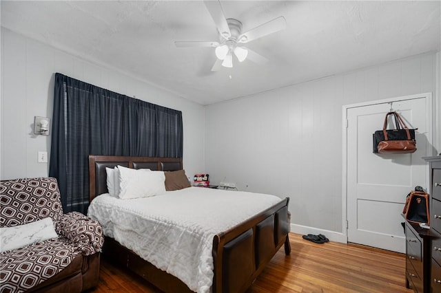 bedroom featuring wood finished floors, baseboards, and ceiling fan