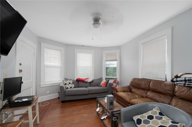 living area with a ceiling fan and dark wood-style flooring
