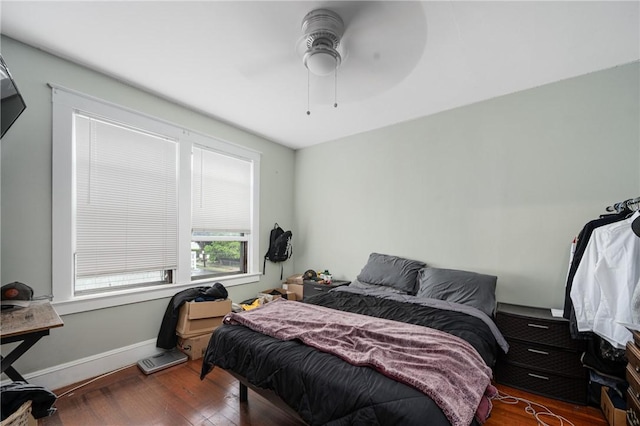 bedroom featuring wood finished floors, baseboards, and a ceiling fan
