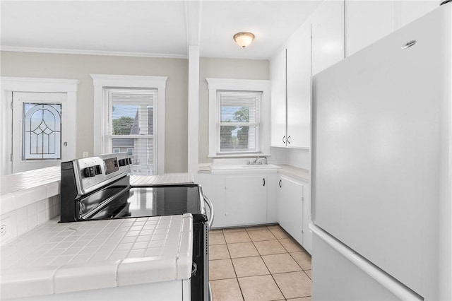 2 Francis St, Coventry, RI 02816 - kitchen featuring freestanding refrigerator, tile countertops, stainless steel electric range oven, white cabinets, and light tile patterned floors