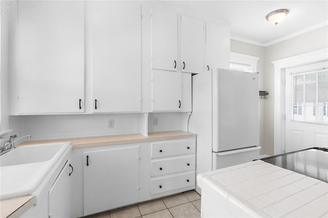 2 Francis St, Coventry, RI 02816 - kitchen with light countertops, white cabinetry, freestanding refrigerator, and light tile patterned flooring
