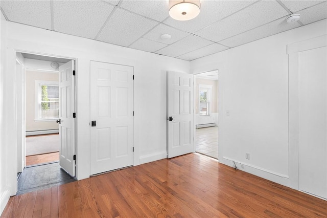 2 Francis St, Coventry, RI 02816 - unfurnished bedroom featuring a paneled ceiling, multiple windows, wood finished floors, baseboard heating, and baseboards
