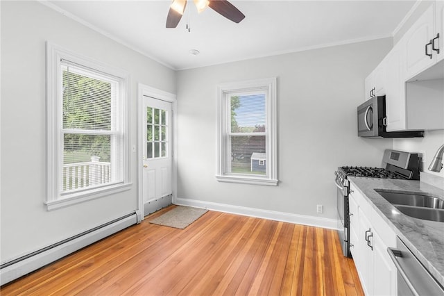 2 Francis St, Coventry, RI 02816 - kitchen with appliances with stainless steel finishes, a baseboard heating unit, light wood-style floors, a sink, and a ceiling fan