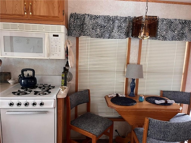 118 Dunns Corner Rd, Westerly, RI 02891 - kitchen featuring white appliances, brown cabinets, light countertops, and pendant lighting