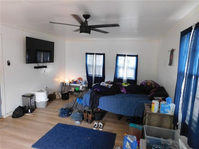 bedroom featuring wood finished floors, ceiling fan, and ornamental molding