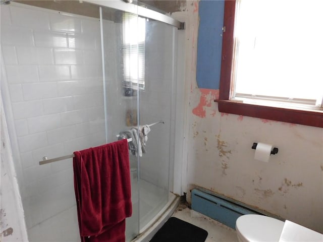 bathroom featuring toilet, a stall shower, and a baseboard radiator