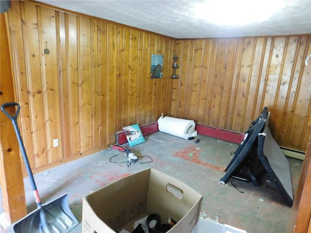 exercise room featuring baseboard heating and wood walls