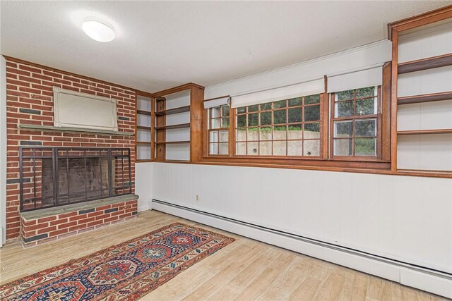 40 Haverhill Ave, North Kingstown, RI 02852 - unfurnished living room featuring a baseboard heating unit, wood finished floors, and a brick fireplace