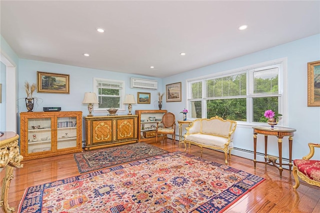 40 Haverhill Ave, North Kingstown, RI 02852 - living area with wood finished floors, recessed lighting, a wall mounted air conditioner, and baseboard heating