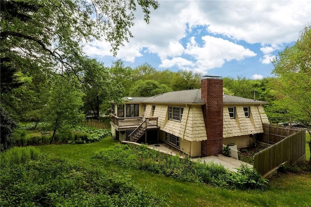 40 Haverhill Ave, North Kingstown, RI 02852 - back of property featuring stairway, a chimney, a wooden deck, a sunroom, and a patio
