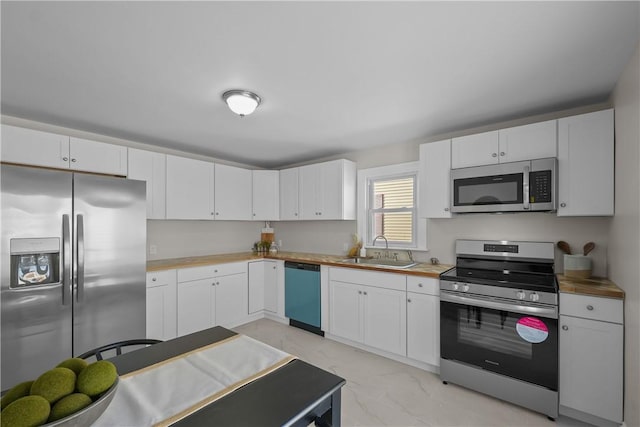 104 Liberty St, Pawtucket, RI 02861 - kitchen with stainless steel appliances, a sink, light marble finish flooring, and white cabinetry