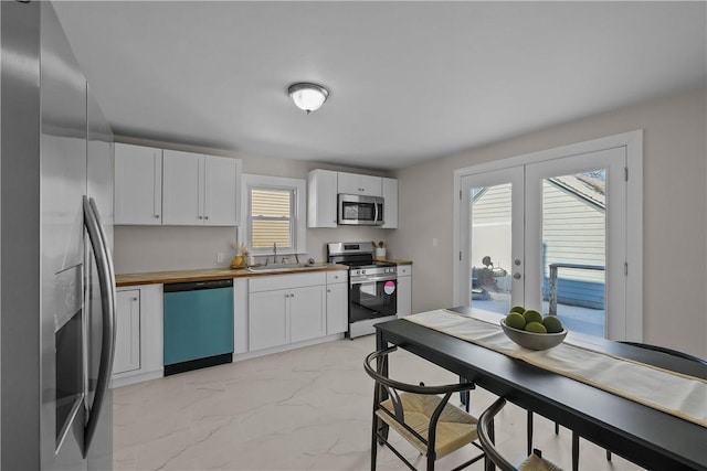 104 Liberty St, Pawtucket, RI 02861 - kitchen featuring stainless steel appliances, wood counters, light marble finish flooring, a sink, and white cabinets