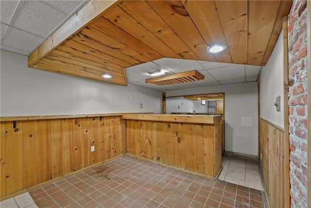 104 Liberty St, Pawtucket, RI 02861 - kitchen with light tile patterned floors, wainscoting, wood walls, and a paneled ceiling