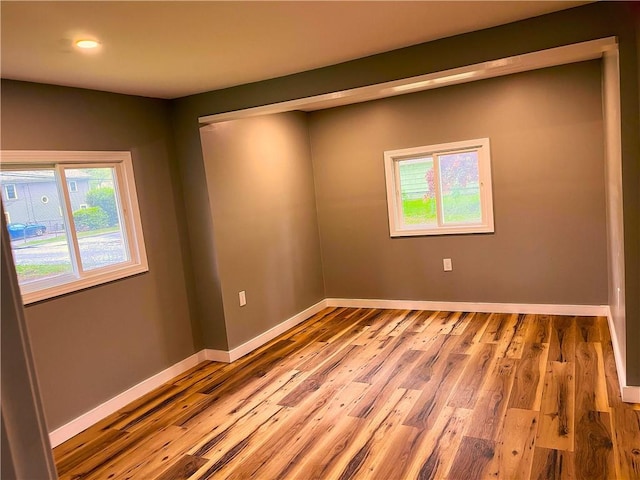 spare room featuring wood finished floors, baseboards, and recessed lighting