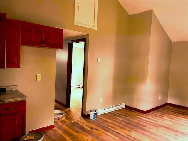 kitchen featuring a baseboard radiator, wood finished floors, and baseboards
