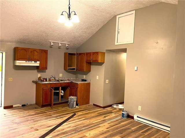 kitchen featuring a baseboard heating unit, a textured ceiling, light wood-style flooring, under cabinet range hood, and lofted ceiling