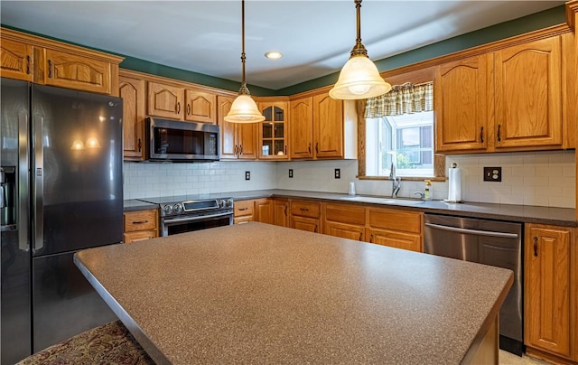 99 Fairfield Ave, Woonsocket, RI 02895 - kitchen with stainless steel appliances, a sink, dark countertops, glass insert cabinets, and brown cabinetry