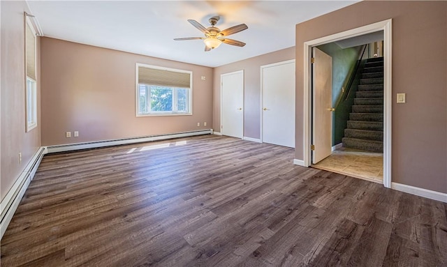 99 Fairfield Ave, Woonsocket, RI 02895 - unfurnished bedroom featuring a baseboard heating unit, dark wood-type flooring, baseboards, and a ceiling fan