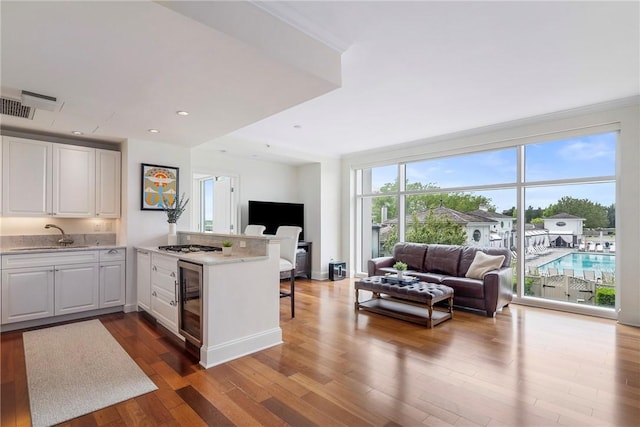 1 Tower Dr Unit 203, Portsmouth, RI 02871 - kitchen featuring open floor plan, a sink, beverage cooler, a peninsula, and dark wood-style floors