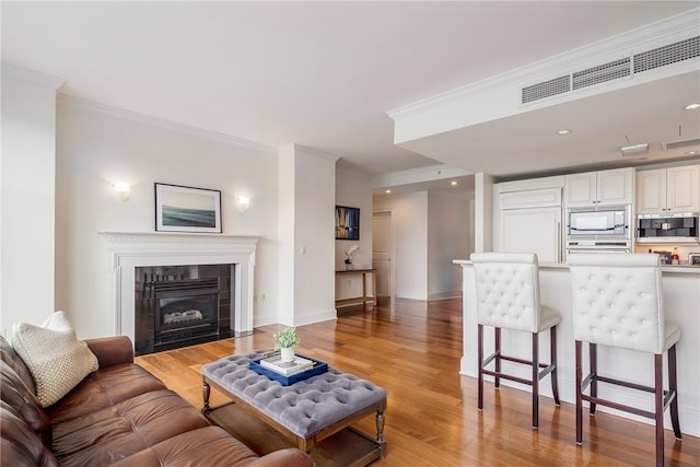 1 Tower Dr Unit 203, Portsmouth, RI 02871 - living room with ornamental molding, light wood-type flooring, a tile fireplace, and baseboards