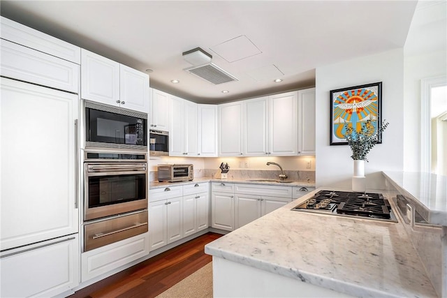1 Tower Dr Unit 203, Portsmouth, RI 02871 - kitchen featuring built in appliances, a warming drawer, a sink, dark wood finished floors, and white cabinets