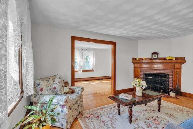 72 Old Danielson Pike, Foster, RI 02825 - living area with baseboards, a brick fireplace, and a baseboard radiator