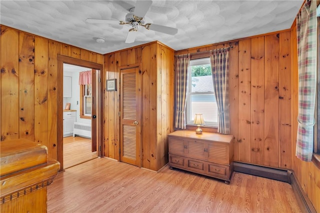72 Old Danielson Pike, Foster, RI 02825 - bedroom with radiator, light wood-style flooring, wooden walls, a closet, and ensuite bath