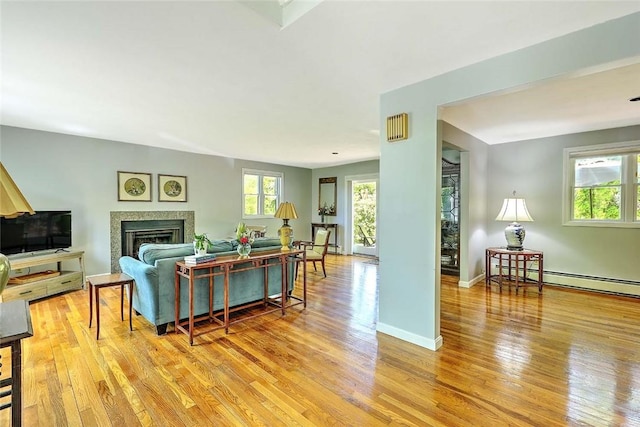 9 Misty River Ter, Narragansett, RI 02874 - living area featuring light wood-type flooring, baseboard heating, baseboards, and a fireplace
