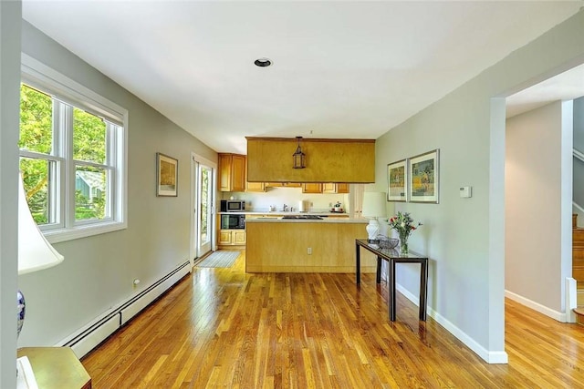 9 Misty River Ter, Narragansett, RI 02874 - kitchen with a baseboard radiator, brown cabinetry, light wood-type flooring, and a peninsula