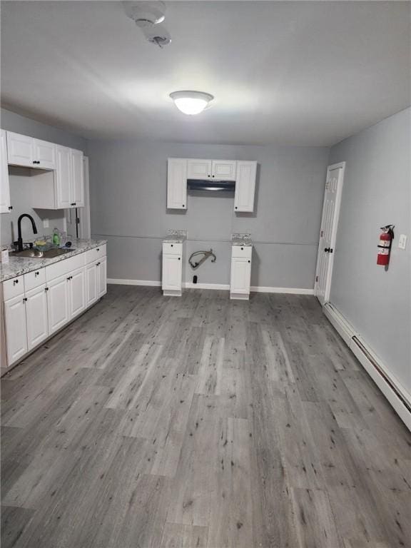 45 Ross St, Woonsocket, RI 02895 - kitchen with a sink, baseboards, wood finished floors, light stone counters, and white cabinets
