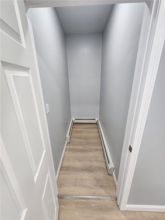 45 Ross St, Woonsocket, RI 02895 - staircase with a baseboard heating unit, a baseboard radiator, and wood finished floors