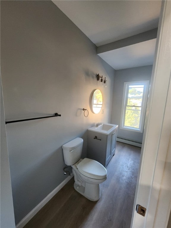 45 Ross St, Woonsocket, RI 02895 - half bath with a baseboard heating unit, wood finished floors, toilet, vanity, and baseboards