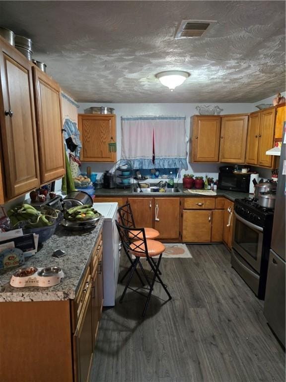 20 Pennsyjvania Ave, Providence, RI 02905 - kitchen featuring gas range, a sink, dark wood-style floors, brown cabinetry, and a textured ceiling