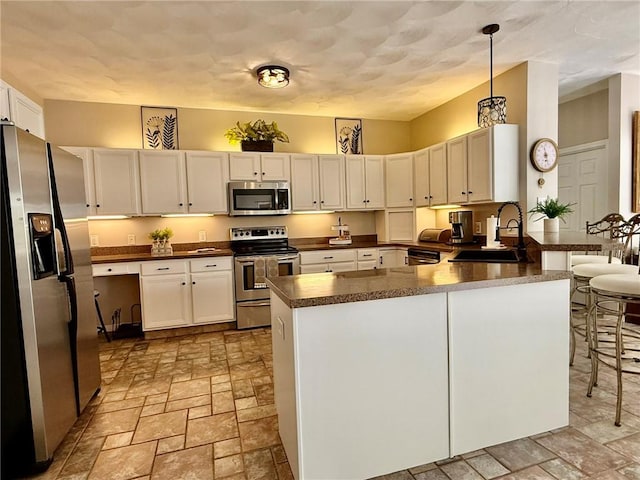 36 Jasmine Cir, North Kingstown, RI 02874 - kitchen with appliances with stainless steel finishes, a sink, light stone finish flooring, and dark countertops