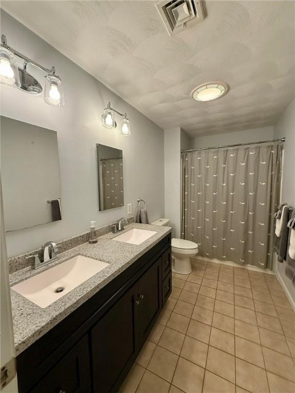 36 Jasmine Cir, North Kingstown, RI 02874 - full bath featuring tile patterned flooring, toilet, double vanity, and a shower with curtain