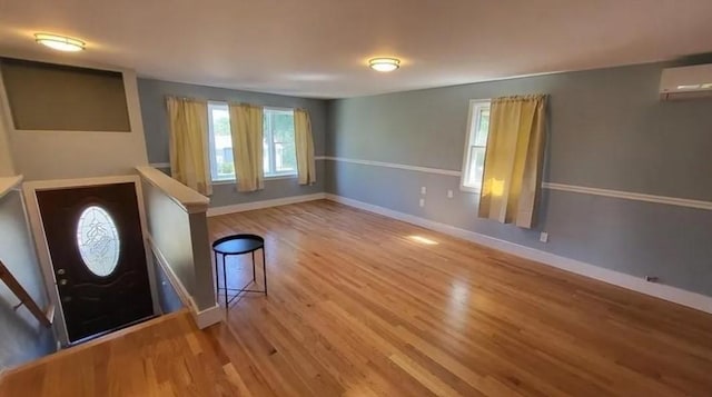 132 Maple Ave, Middletown, RI 02842 - foyer entrance featuring an AC wall unit, wood finished floors, and baseboards