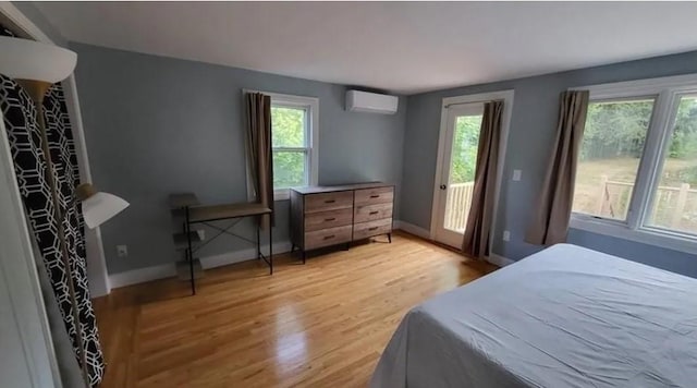 132 Maple Ave, Middletown, RI 02842 - bedroom with access to exterior, a wall mounted air conditioner, light wood-style flooring, and multiple windows