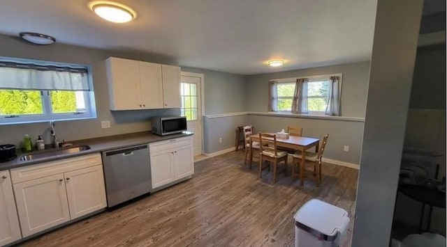 132 Maple Ave, Middletown, RI 02842 - kitchen with appliances with stainless steel finishes, a sink, dark countertops, baseboards, and wood finished floors