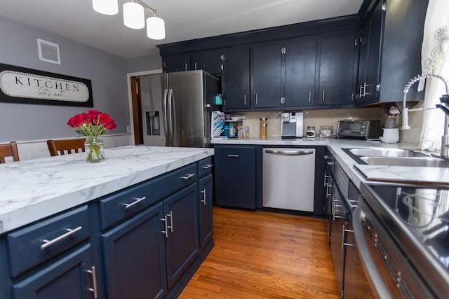 60 Sumach Ave, East Providence, RI 02915 - kitchen with stainless steel appliances, tasteful backsplash, light wood-type flooring, and blue cabinets