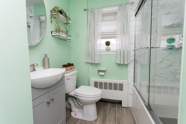 60 Sumach Ave, East Providence, RI 02915 - full bathroom with radiator heating unit, toilet, vanity, combined bath / shower with glass door, and wood finished floors