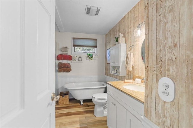 52 Eddy St, North Providence, RI 02911 - full bathroom with wood finished floors, a freestanding bath, vanity, toilet, and a wainscoted wall