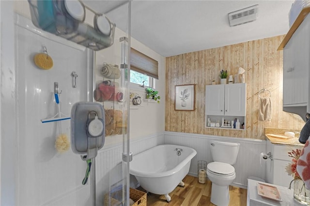 52 Eddy St, North Providence, RI 02911 - full bath with wood finished floors, a soaking tub, wainscoting, toilet, and wooden walls