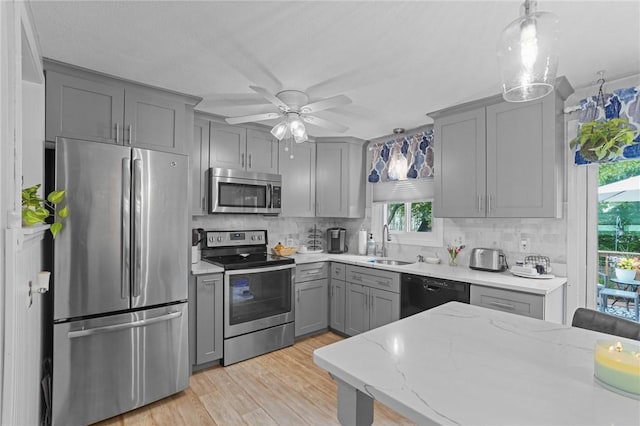 52 Eddy St, North Providence, RI 02911 - kitchen featuring stainless steel appliances, gray cabinets, a sink, tasteful backsplash, and a ceiling fan