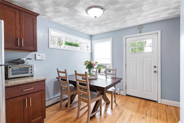 27 Aberdeen St, West Warwick, RI 02893 - dining area featuring a baseboard heating unit, light wood-style flooring, baseboards, and baseboard heating